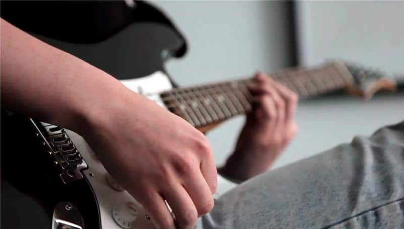 Closeup of hands playing an electric guitar